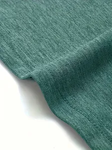 Detailopname van groenblauwe gebreide stof met duurzame dubbelnaalds stikselafwerking.