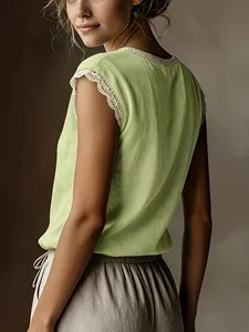 Dettaglio posteriore di maglia in cotone e lino verde con bordo in pizzo.
