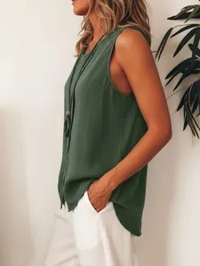 Profile view showing the loose fit of a dark green sleeveless button-down shirt