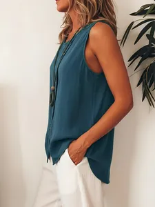 Side detail view of loose sleeveless button-up blouse with linen-like texture in teal