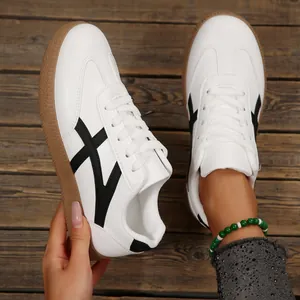 Détail des baskets blanches de style GAT pour femmes avec semelle en gomme et bandes noires