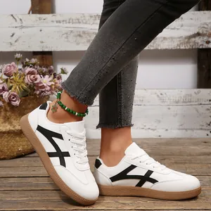 Détail latéral de baskets blanches pour femmes avec rayures noires et semelle en gomme