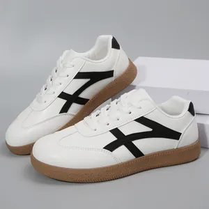 Vue détaillée des baskets blanches style allemand avec bandes noires et semelle gomme