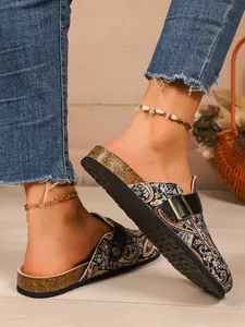 Vue détaillée des sabots à motif paisley avec semelle en liège et boucle noire