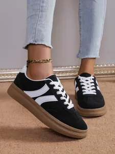 Détail de baskets compensées noires pour femmes avec rayures blanches et semelle.