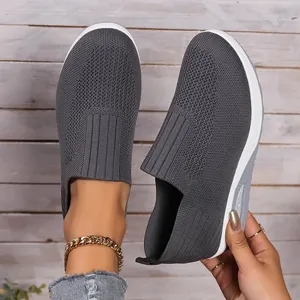 Detailed view of grey breathable flyknit mesh slip-on shoe with thick soft sole