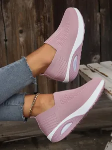 Detail view of breathable pink fly-knit slip-on sneakers with thick comfort sole
