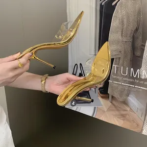 Primo piano di sabot dorati a punta con cinturini trasparenti e eleganti tacchi a spillo