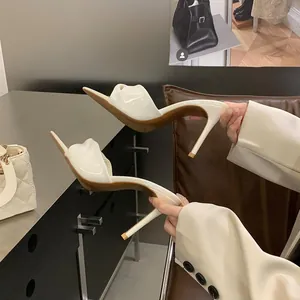 Nahaufnahme von eleganten weißen High-Heel-Sandalen mit spitzer Zehenpartie