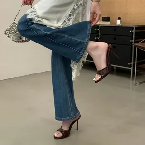 Elegant brown patent leather stiletto mules styled with denim jeans for a chic look