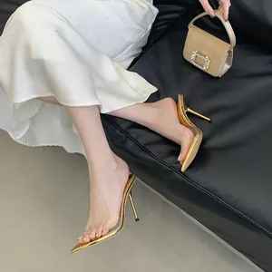 Vista dettagliata di eleganti sabot dorati a punta con cinturini in PVC su modella.