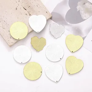 Detailansicht strukturierter Herz- und Rundanhänger aus Gold und Silber für DIY-Schmuck