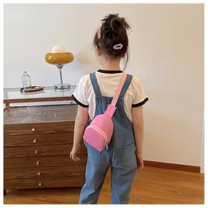 Vue de dos d'un enfant portant un sac de poitrine en nylon rose léger à la maison