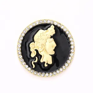 Detailansicht eines goldfarbenen Charm-Anhängers mit schwarzer Emaille und Strass.