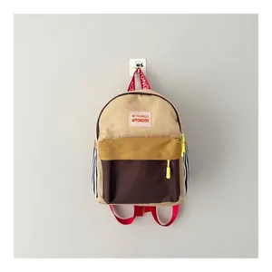 Dettaglio di uno zaino alla moda per bambini color block con spallacci rossi vivaci.