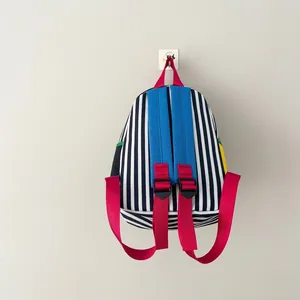 Vista posteriore dettagliata di uno zaino a righe per bambini con spallacci blu e rossi
