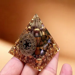 Detailansicht einer 5cm Tigerauge Harz Orgon-Pyramide mit Goldfolie und Metallspirale