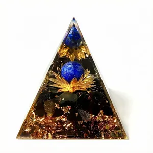 Detailansicht einer Orgonit-Pyramide mit Goldfolie, Lotus und blauer Kristallkugel