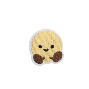 Cute shuttlecock embroidered patch with smiling face for kids' clothing decoration.