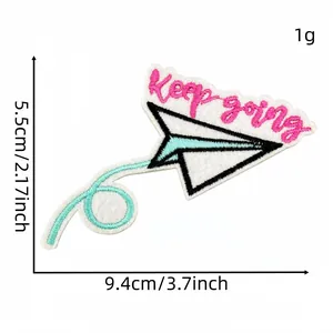 Detailed view of embroidered paper airplane patch with 'Keep going' text and dimensions.