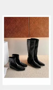Vista detallada de botas minimalistas de cuero negro en versión corta y de media caña