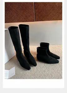 Detalle de botas de ante negro con punta cuadrada y cremallera posterior