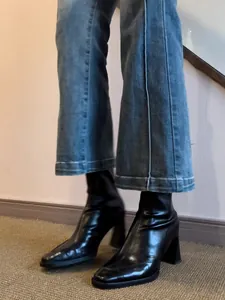 Close-up of black leather square-toe high-heeled ankle boots with chunky heel