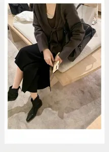 Elegante vista de botines de cuero negro con punta cuadrada y cremallera trasera.