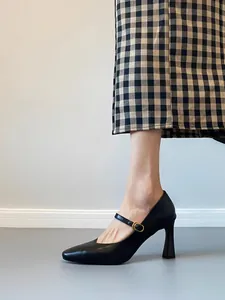 Elegant black leather Mary Jane heels with vintage buckle strap and stylish block heel.