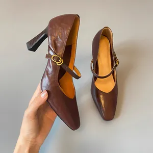 Detail shot of brown leather Mary Jane heels with retro buckle and chunky high heel.