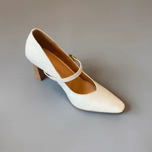 Side detail view of a white vintage Mary Jane block heel shoe with elegant leather texture