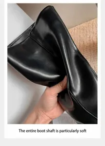 Vista detallada que muestra el material de cuero negro suave y texturizado de la bota