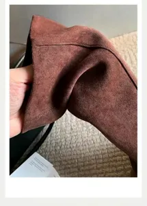Detalle macro que muestra la textura suave del cuero de ante marrón en las botas de mujer.