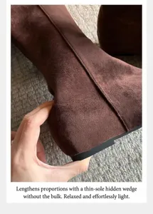 Vista detallada de botín de ante marrón con cuña interna de 5 cm y textura de material