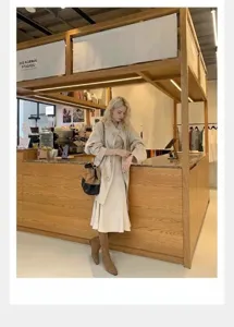 Modelo luciendo botas minimalistas de cuero con punta cuadrada en una cafetería.