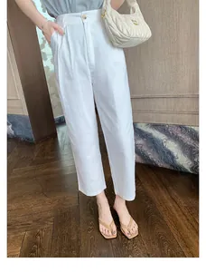 Elegante beige flache Zehentrenner aus echtem Leder zu einer weißen Sommerhose kombiniert