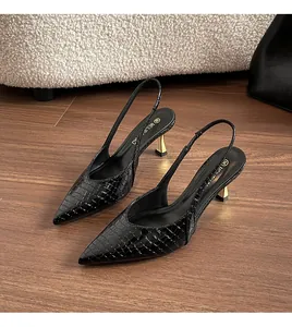 Macro detail of elegant black crocodile pattern slingback pumps with stylish golden heels