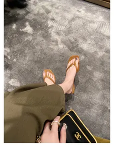 Detailaufnahme von braunen Flip-Flop-Sandalen aus Leder mit quadratischer Zehenpartie