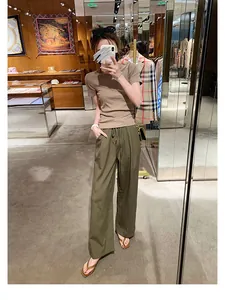 Vollansicht einer Frau in braunen Echtleder-Zehentrennern in einem Boutique-Ambiente
