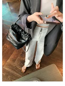 Detailansicht der stilvollen braunen Leder-Zehentrenner mit weißer Hose und Blazer