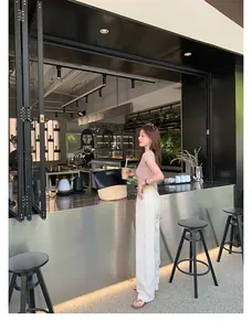 Elegante flache Zehentrenner aus Leder für Damen in einem stilvollen Café-Ambiente