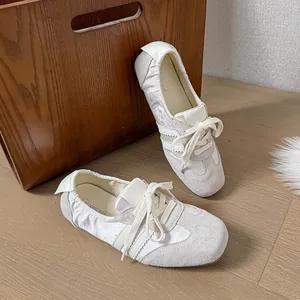 Nahaufnahme von weißen Ballett-Flachschuhen aus Leder mit eckiger Zehenpartie und Schnürung