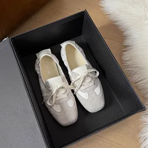 Nahaufnahme von cremefarbenen Leder-Ballerinas in einer schwarzen Geschenkverpackung