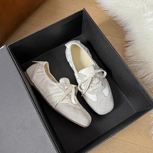 Detailaufnahme der cremefarbenen Leder-Ballerinas mit Streifendesign in einer schwarzen Box