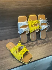 Nahaufnahme der schicken Retro-Damenhausschuhe mit eckiger Zehenpartie und Doppelschleife