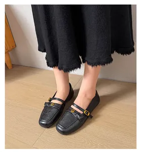 Detailed view of elegant black Mary Jane flats featuring a rose ornament and strap.