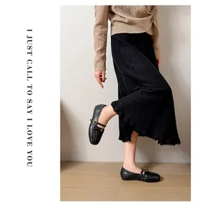 Detail of black Mary Jane flat shoes with square toe worn by a model in a studio