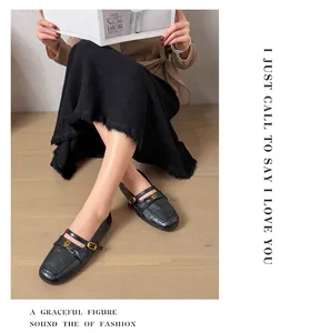 Elegant black Mary Jane loafers with gold floral accents shown on a female model.