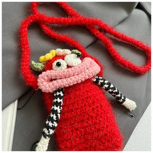 Detail view of handmade knitted red crossbody bag with a funny big mouth design