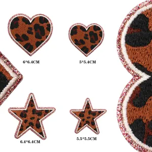Close-up view of leopard print heart and star patches with glitter borders and dimensions.